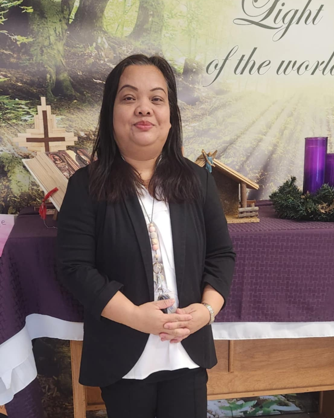 Adult woman smiling in front of an altar