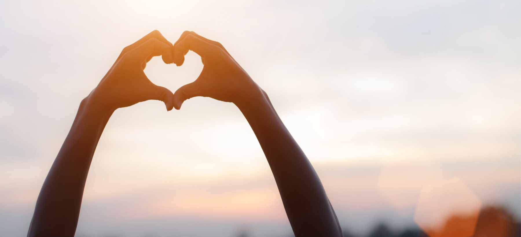 hands forming a heart in the sky