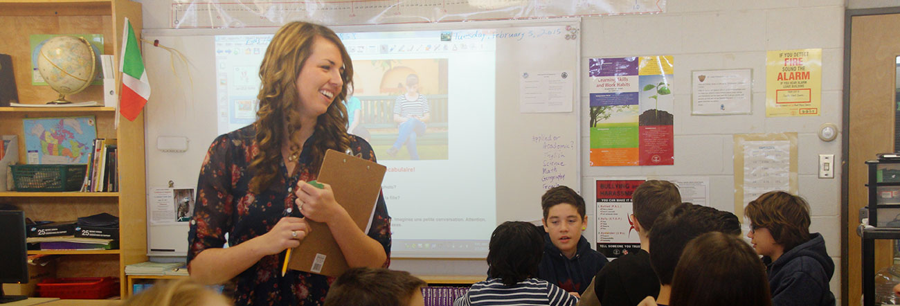 Female teacher talking to class with presentation slide in background