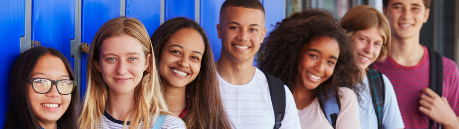 Group of female and male students standing in front of lockers