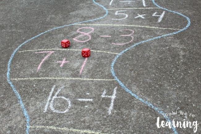 Math addition, subtraction and multiplication questions on a chalk pathway