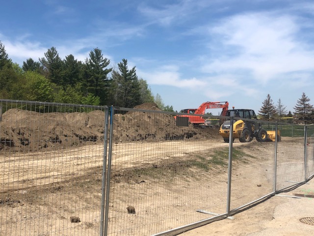 Construction vehicle remove scraping the soccer field outside