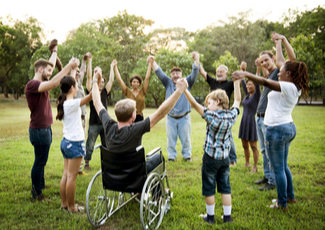 People outside holding hands in a circle