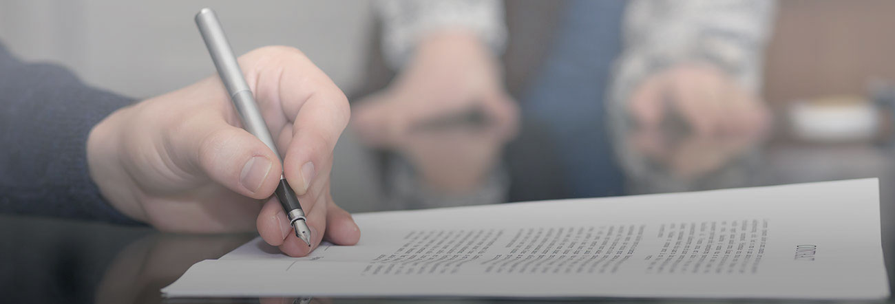 Hand holding pen writing in a note book