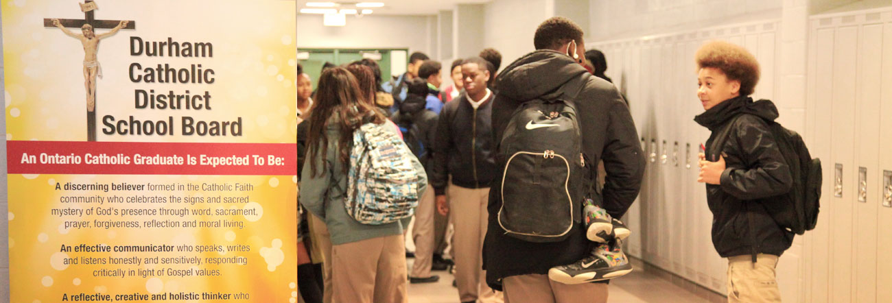 Students in hallway with Catholic Graduate Expectations banner