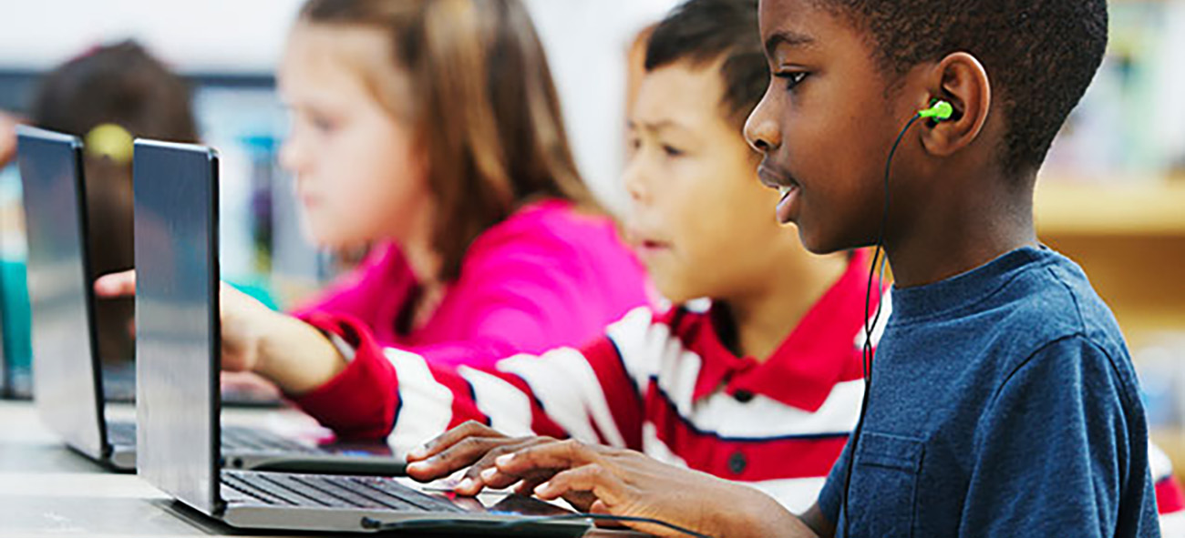 Two male and one female student on laptops