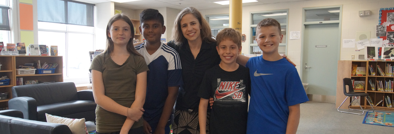 Female adult with female student and three male students in Learning Commons