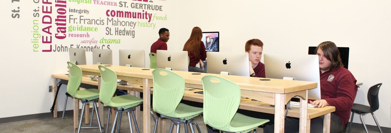 Students with computers at a table