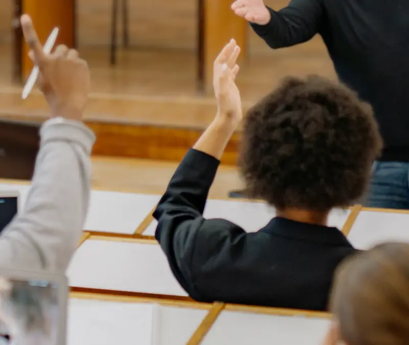 students raising their hand in class