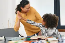 woman and child high fiving